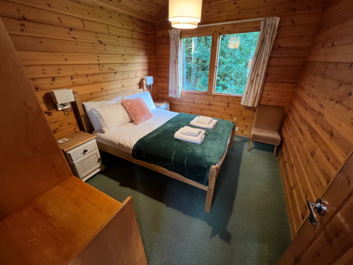 A double bed room with wood cladding on the walls