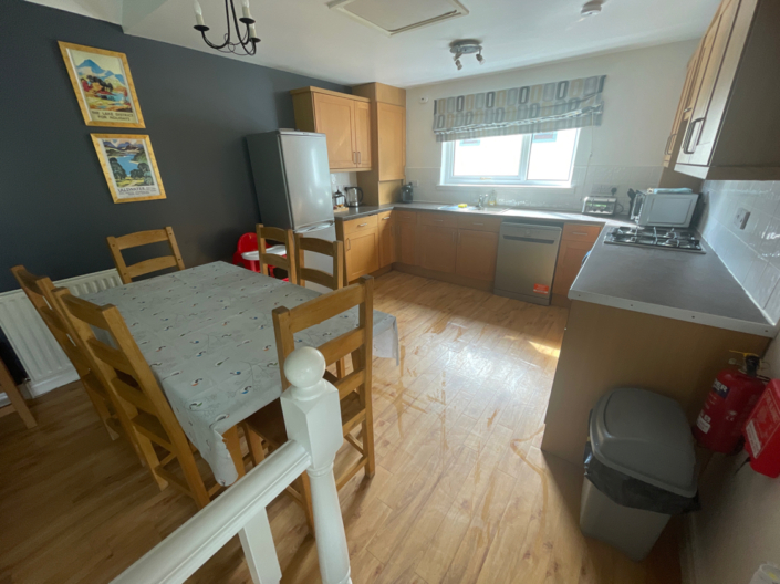 A dining kitchen with appliances and table and chairs